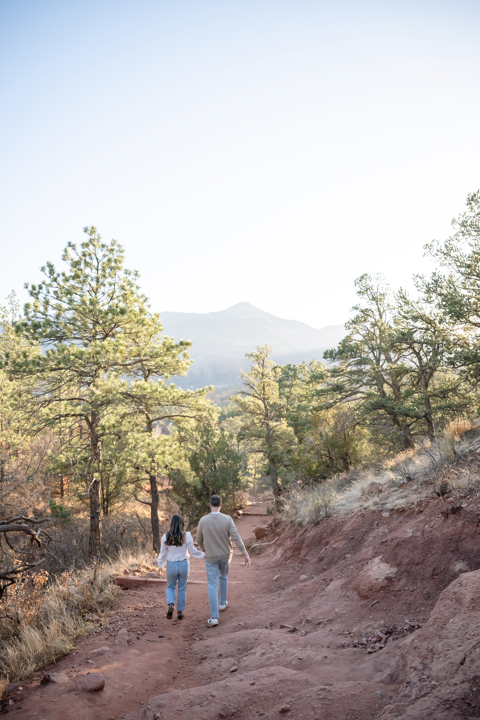 Siamese Twins Garden of the Gods engagement photography, couple walking on trail