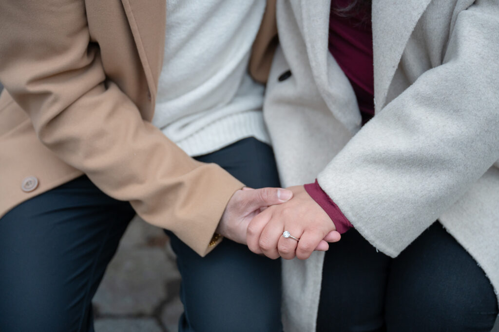 holding hands with engagement ring