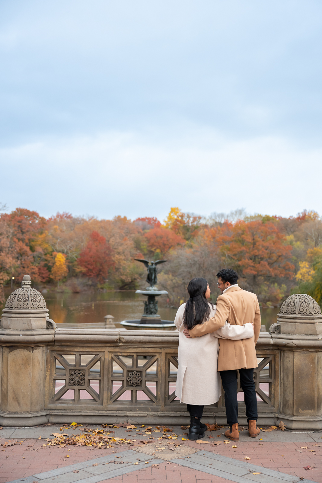 Couple in autumn looking at angel fountain in Central Park