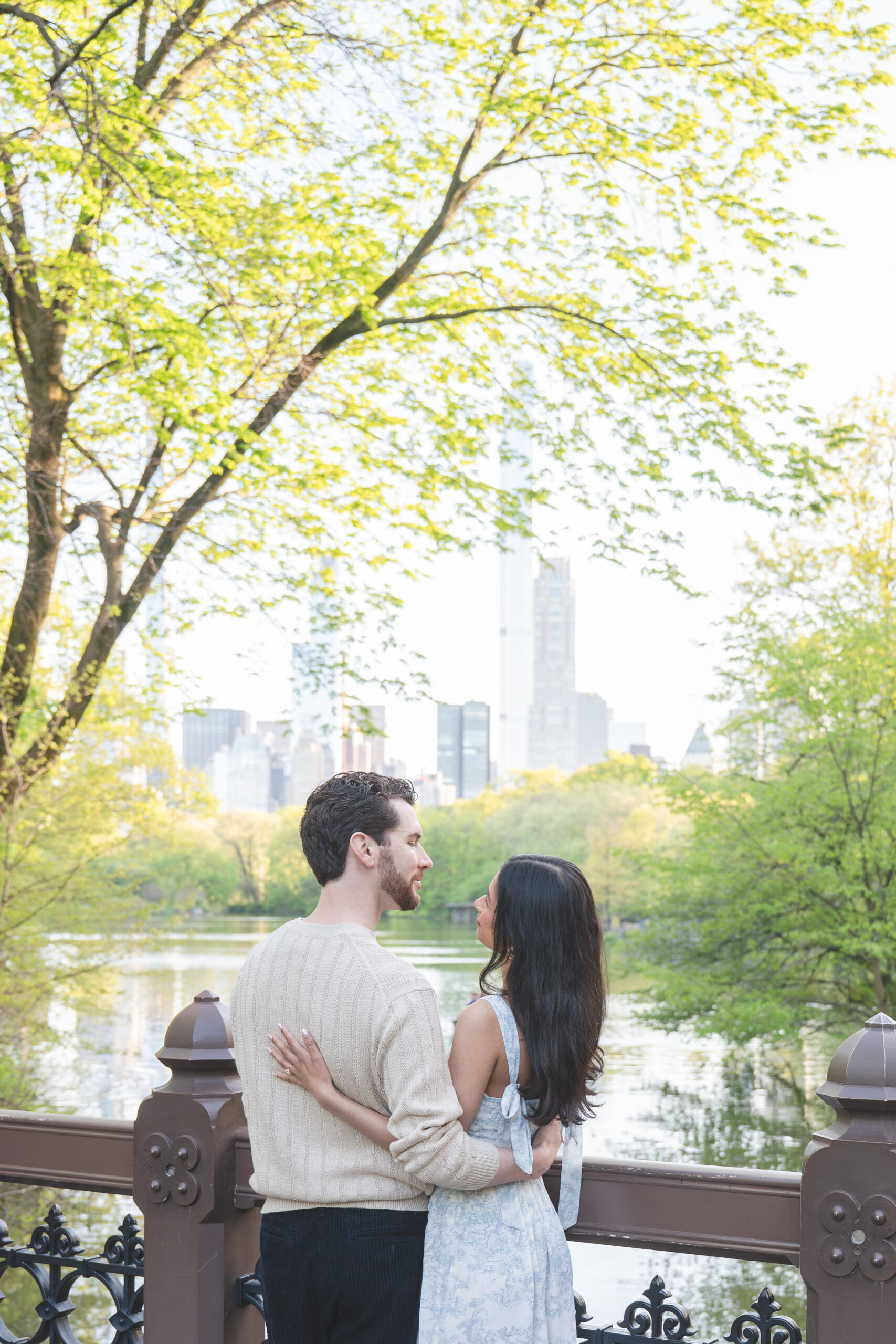couple on a bridge in central park, nyc engagement photography